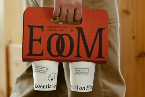 Red cardboard coffee holder with bold EoM typography over white cups