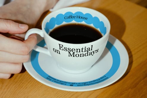 Coffee cup mockup with Essential on Mondays text, ideal for graphic design projects, branding, and promotional templates for designers.