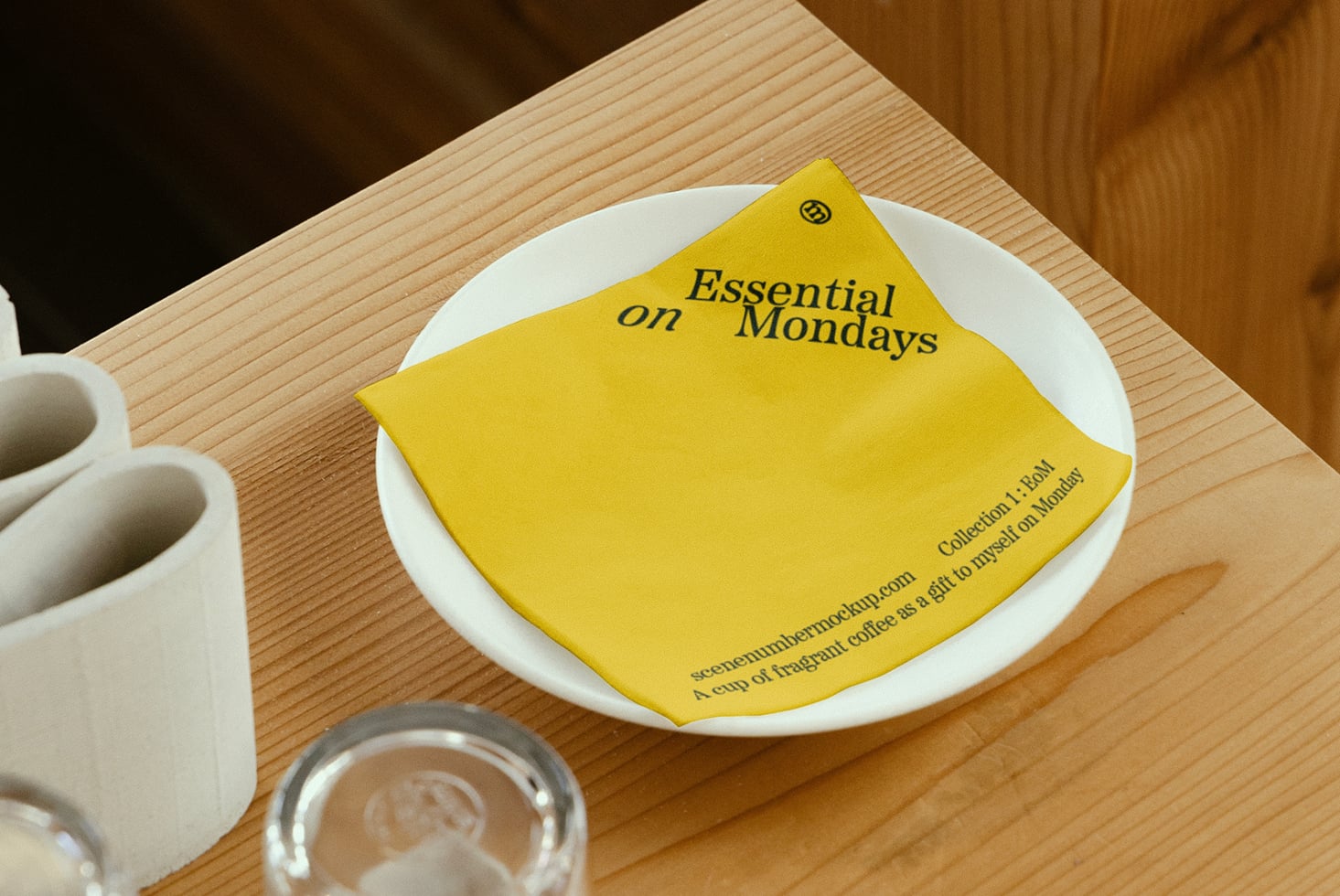 Yellow paper coaster with Essential on Mondays text on plate