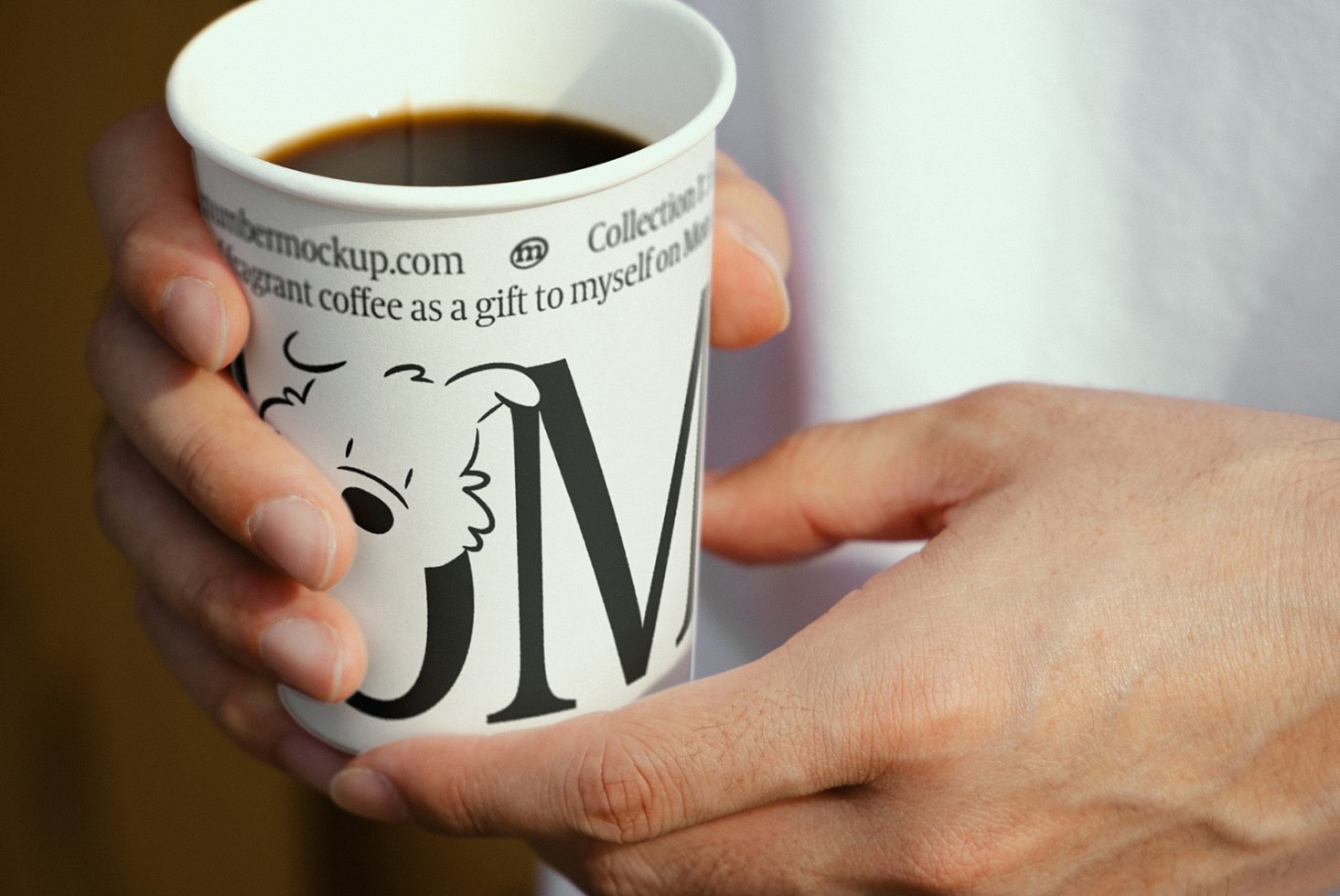 Close-up of hands holding a coffee cup with playful typography and illustration. Ideal for branding mockups or graphic design projects.