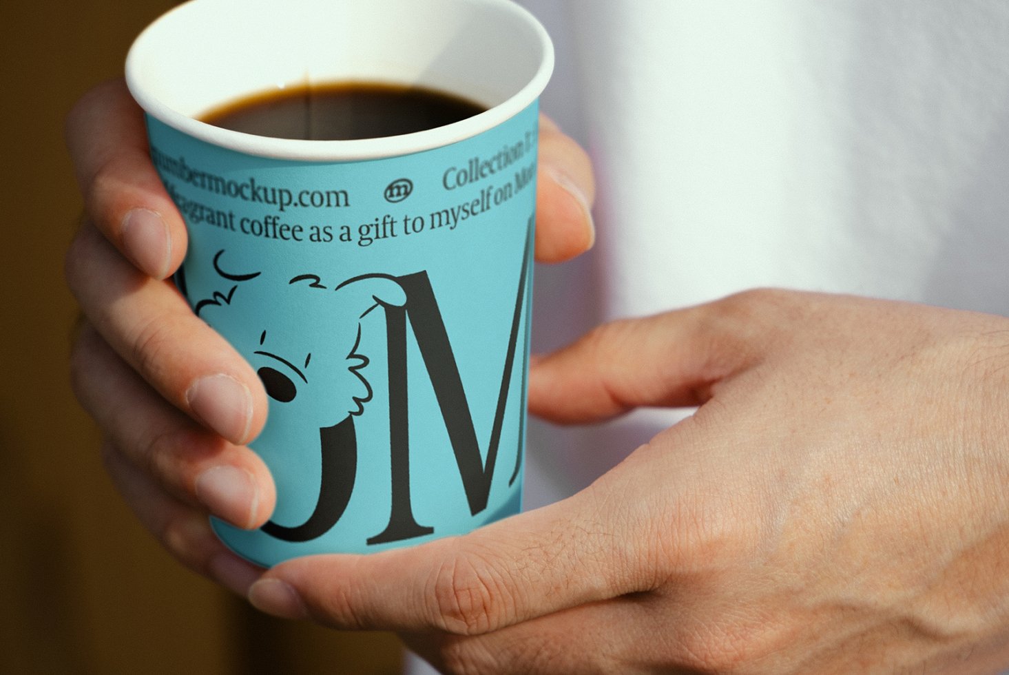 Hand holds a blue coffee cup with graphic design, showcasing elegant font and illustration perfect for branding mockups and product templates for designers.