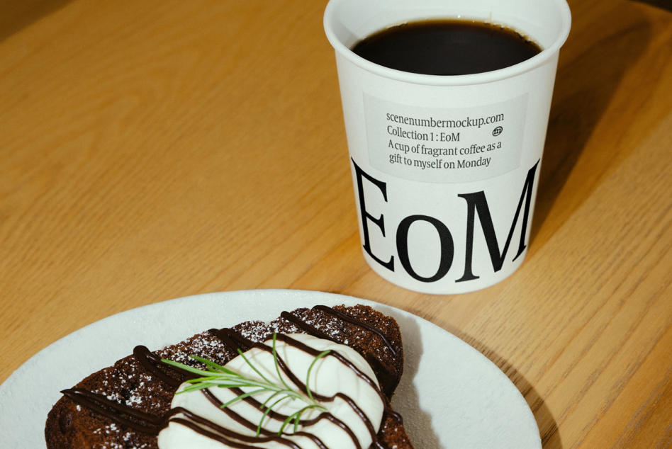 Overhead shot of white coffee cup with chocolate cake on wooden surface