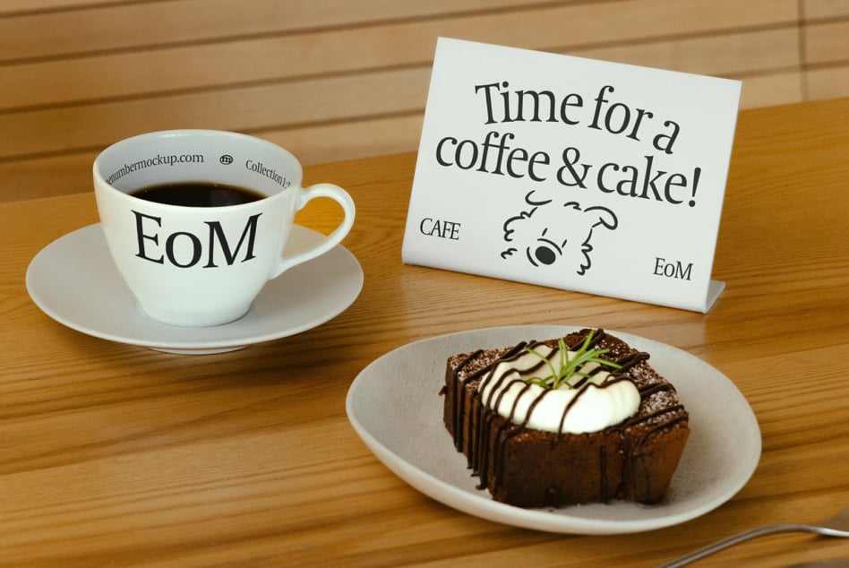 Café table setup with coffee cup, chocolate cake, plus yellow sign reading time for coffee cake