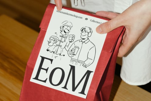 Red paper bag held by person featuring stylish illustration and bold font label titled EoM ideal for graphic design and mockup projects designers