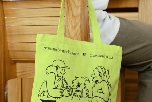 Yellow tote bag with black line art of characters holding mugs, hung on a wooden chair. Suitable for product mockup, design asset, branding template.