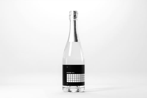 Minimalist bottle design mockup featuring a sleek champagne bottle with a modern label against a white background ideal for designers and branding.