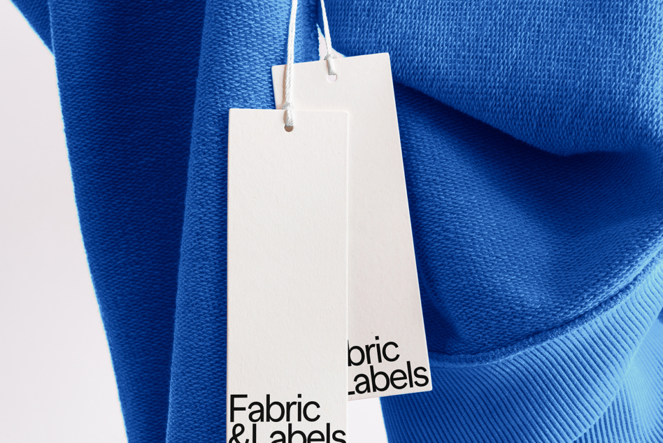 Bright blue knit fabric with layered white hang tag labels mockup