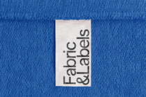 White label tag on blue knit fabric with Fabric Labors text