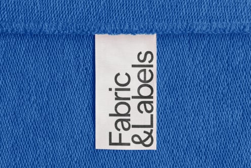 Close-up of a blue fabric with a white label reading Fabric and Labels. Perfect for textile mockup, fabric design templates, and graphic branding projects.