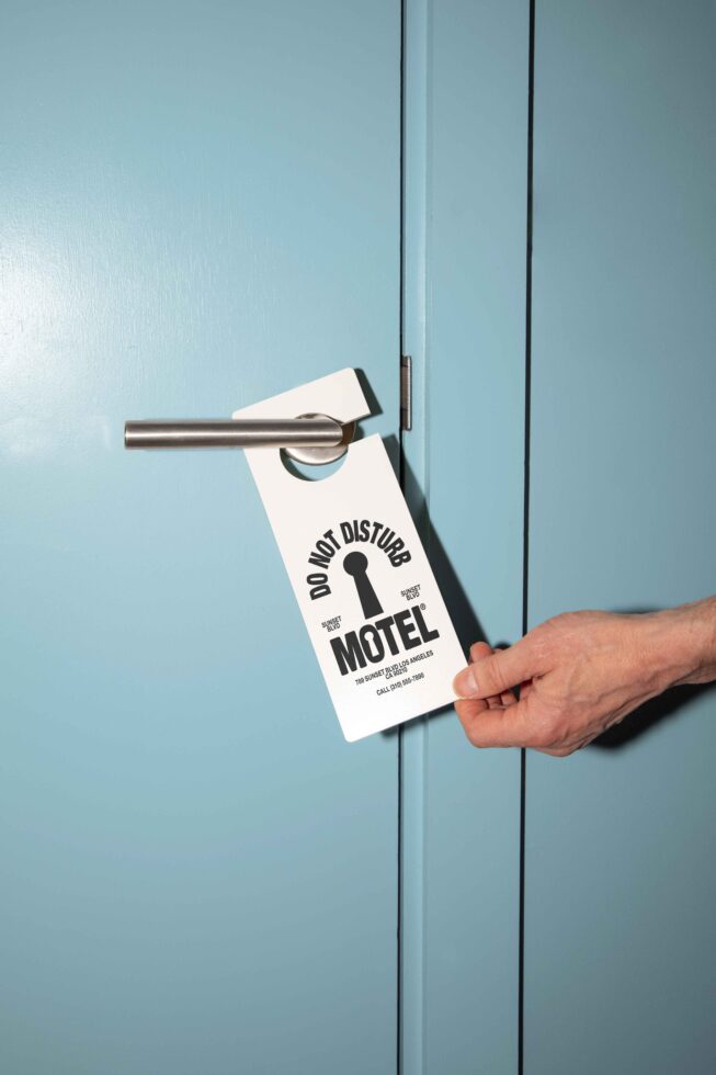 Do not disturb door hanger mockup on a blue door with a modern handle perfect for hotel or motel branding projects graphic design template assets