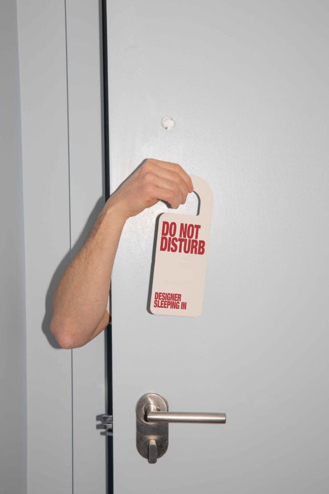 Arm holds a Do Not Disturb sign on a door handle. Perfect for mockups, templates, and graphics designers. Keywords: designer, mockup, template, graphics.