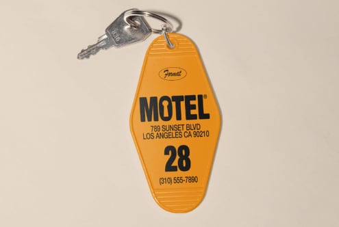 Orange motel key tag with room number 28 and keys, useful for graphic design projects, retro templates, vintage mockups, and travel graphics.