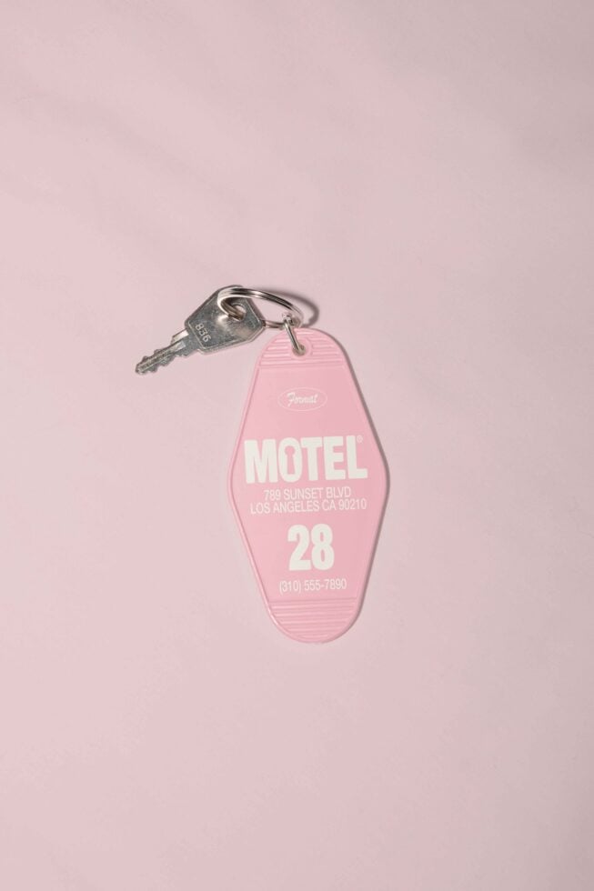 Pink motel keychain with key on light pink background vintage travel mockup for designers retro tag template graphic design asset branding inspiration.