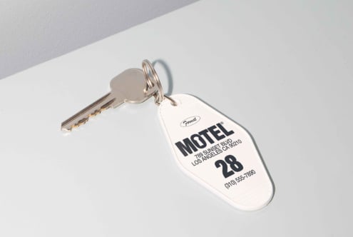 Key with motel tag laying on surface mockup Los Angeles black text white background suitable for branding design packaging hotel graphic designers asset