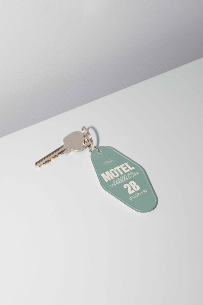 Vintage motel key mockup featuring a single key attached to a green key tag with motel information. Ideal for design projects and templates.