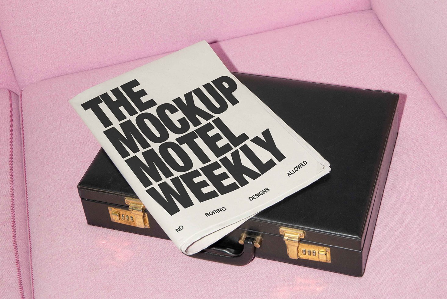 Newspaper mockup on a black briefcase with pink fabric background perfect for designers seeking creative mockups typography and branding resources.