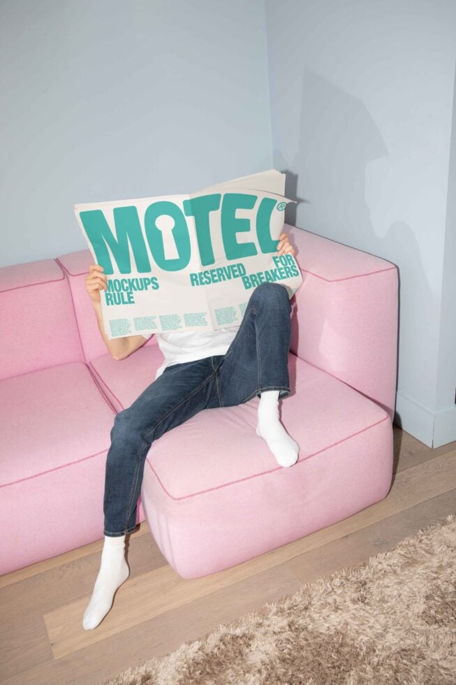 Designer on pink sofa holding large newspaper about mockups. Vibrant scene for showcasing modern mockup designs. Ideal for creative marketing assets.