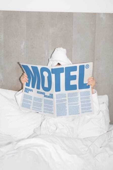 Person in white bathrobe reads a large newspaper with bold blue text Motel emphasizing mockup design ideal for graphic and template designers relaxation scene