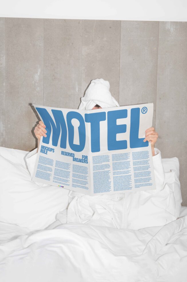 Person in white bathrobe reads a large newspaper with bold blue text Motel emphasizing mockup design ideal for graphic and template designers relaxation scene