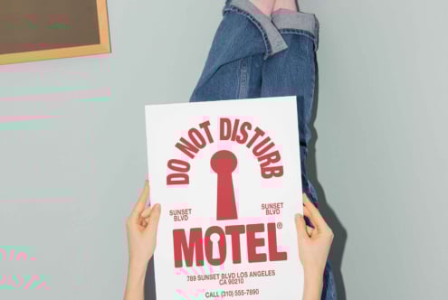 Person holding a poster with Do Not Disturb design in bold red font motel theme for template use ideal for designers seeking unique graphics and mockups