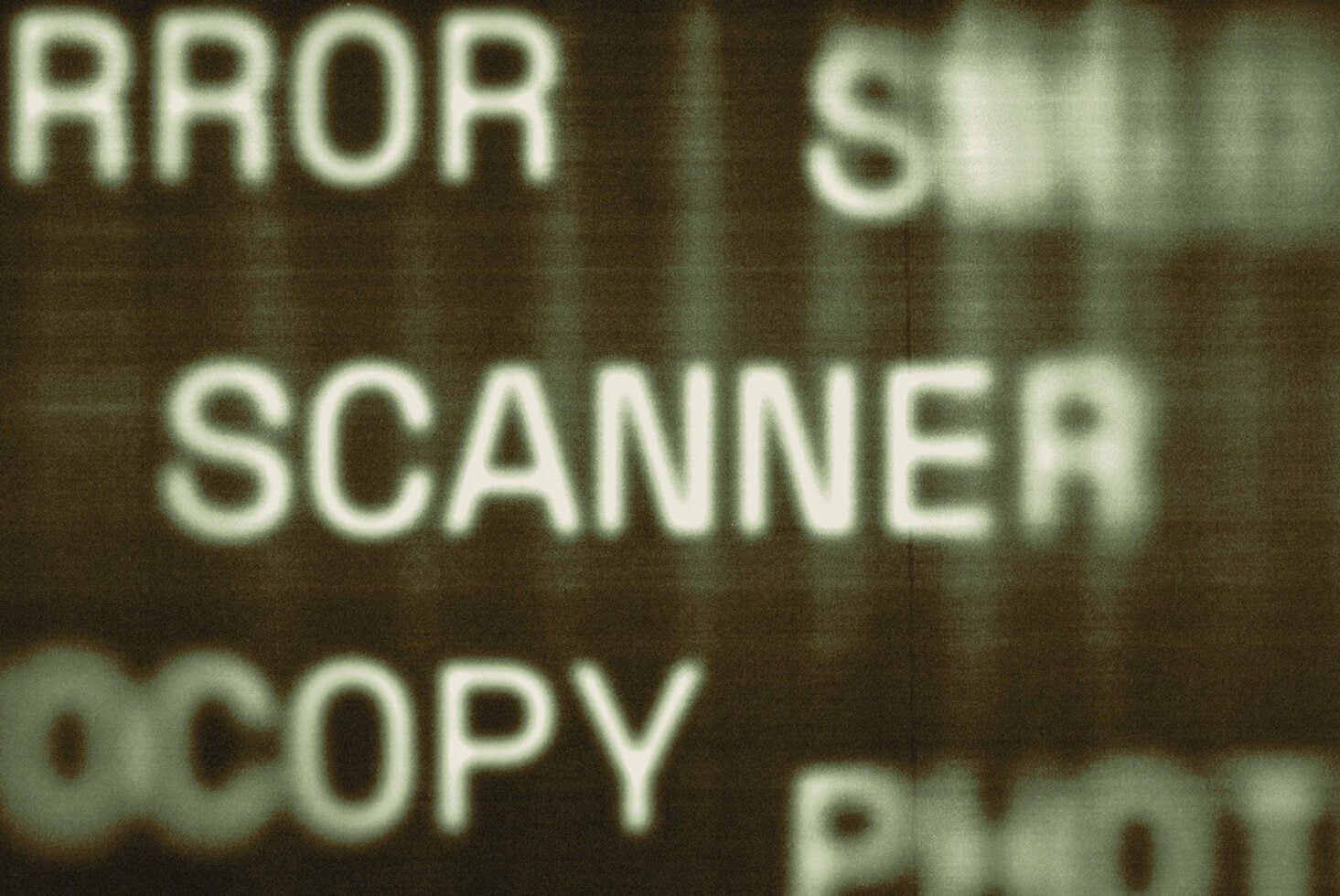 Blurred retro text reading ERROR SCANNER COPY in pale green on dark background