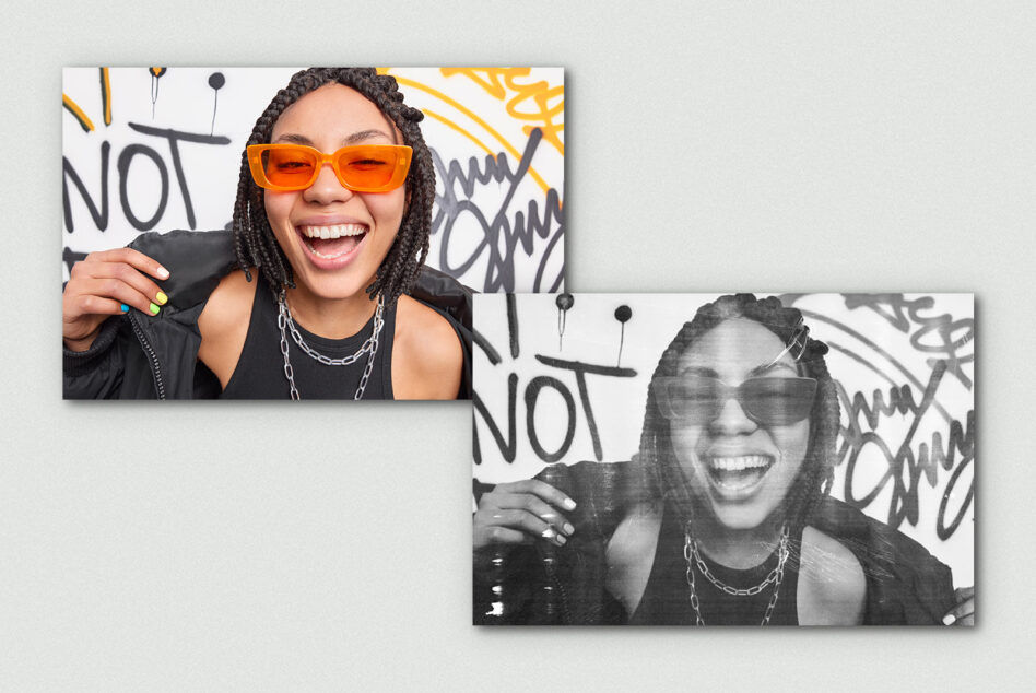 Smiling person in orange sunglasses next to black white version against graffiti wall