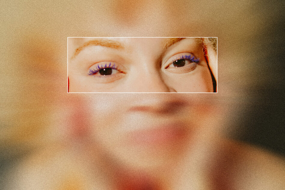 Close-up of eyes with purple eyeliner on warm beige toned background