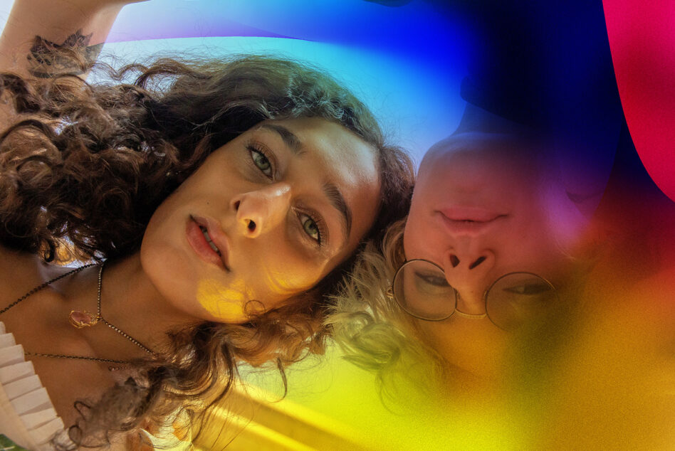 Two people tilted composition with vibrant gradient overlay cyan to magenta