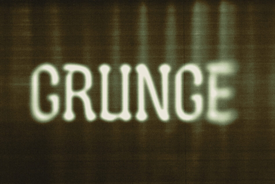 Soft glowing GRUNGE text in pale green on dark striped background, vintage feel