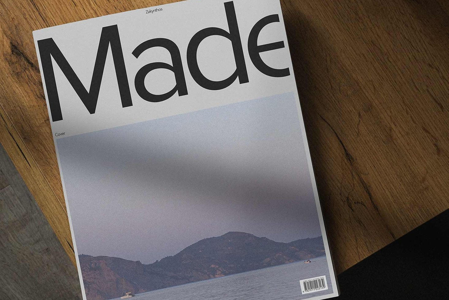 Magazine cover mockup on wooden table featuring minimalist design and landscape photo. Perfect for showcasing editorial templates and layouts to designers.