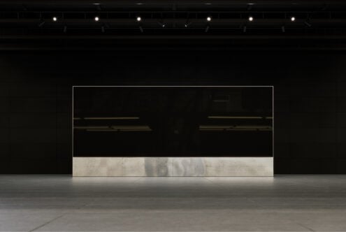 Minimalist modern gallery interior with large black panel, concrete base, and bright spotlights. Perfect for mockups, presentation templates, sleek design.