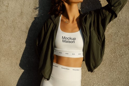 Fashion mockup featuring a woman in branded sportswear with crop top and leggings. Ideal for designers seeking apparel templates for branding or graphics.