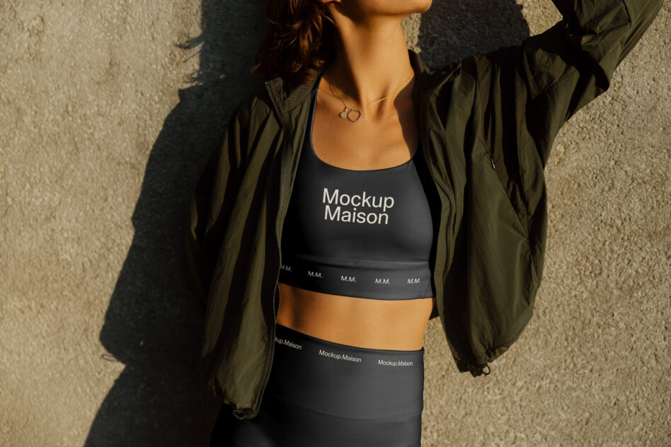 Woman wearing black sports bra with text print under olive jacket