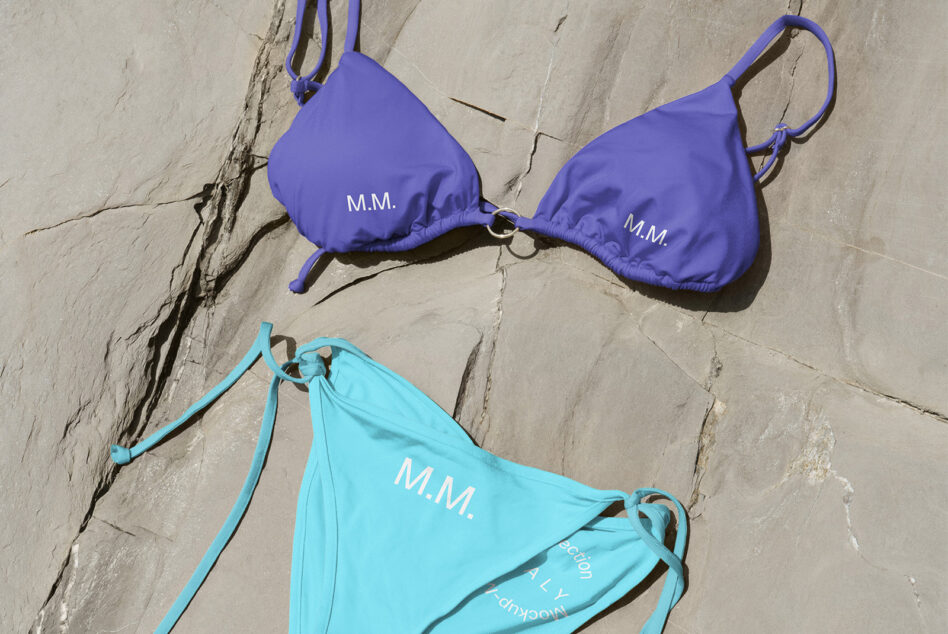 Purple bikini top, turquoise bikini bottom with monogram on grey slate