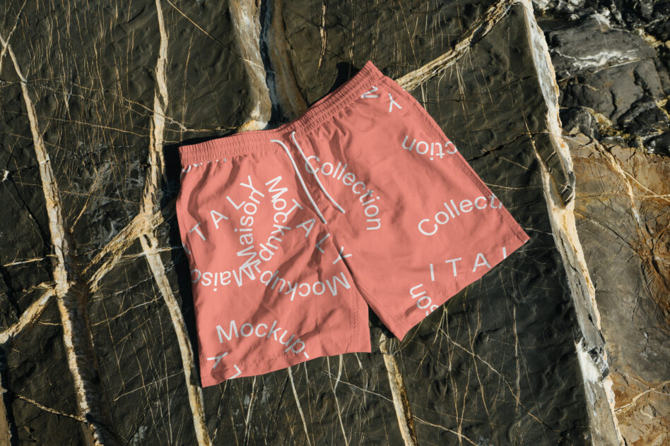 Coral swim shorts on rustic wood background with diagonal text overlay