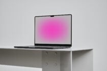 Minimalist laptop mockup with pink screen display on white desk background isolated for designers. Ideal for showcasing website or app designs