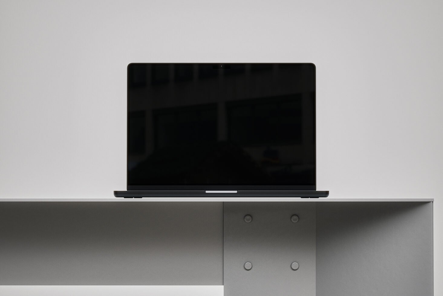 Minimalistic laptop mockup on a grey desk, ideal for showcasing website designs and presentations. Perfect for graphic designers and creatives seeking templates.