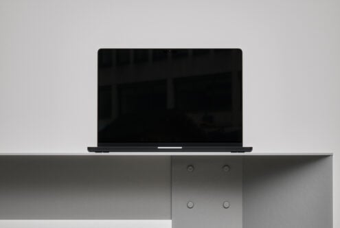 Minimalistic laptop mockup on a grey desk, ideal for showcasing website designs and presentations. Perfect for graphic designers and creatives seeking templates.