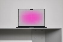 Laptop mockup on a minimalist shelf with vibrant pink screen glow ideal for showcasing digital designs, templates, or graphics for designers.