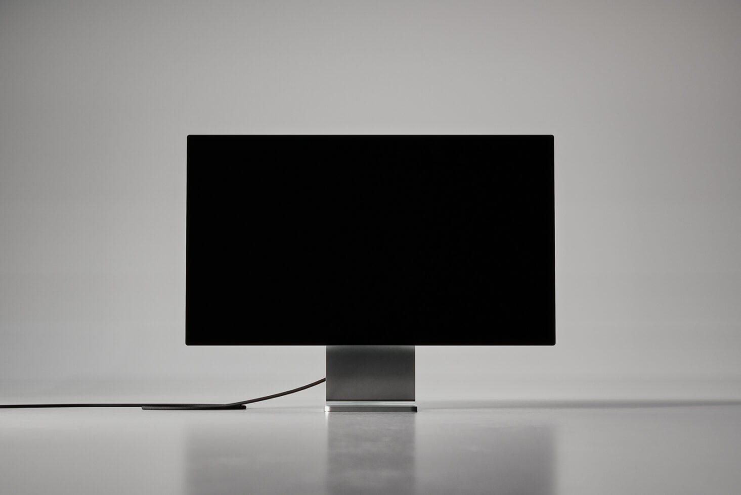 Desktop monitor with black frame on gray pedestal stand, blank screen
