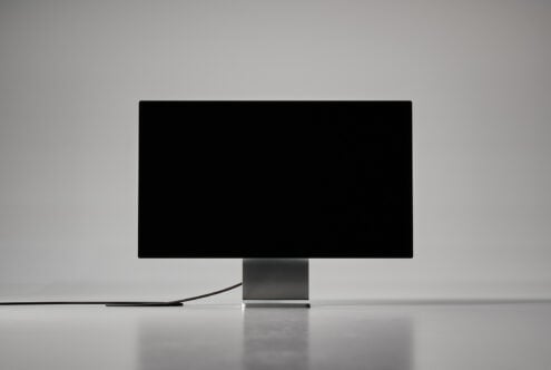 Minimalist digital monitor mockup for designers showcasing a sleek black screen on a modern stand ideal for UI design presentations and templates.