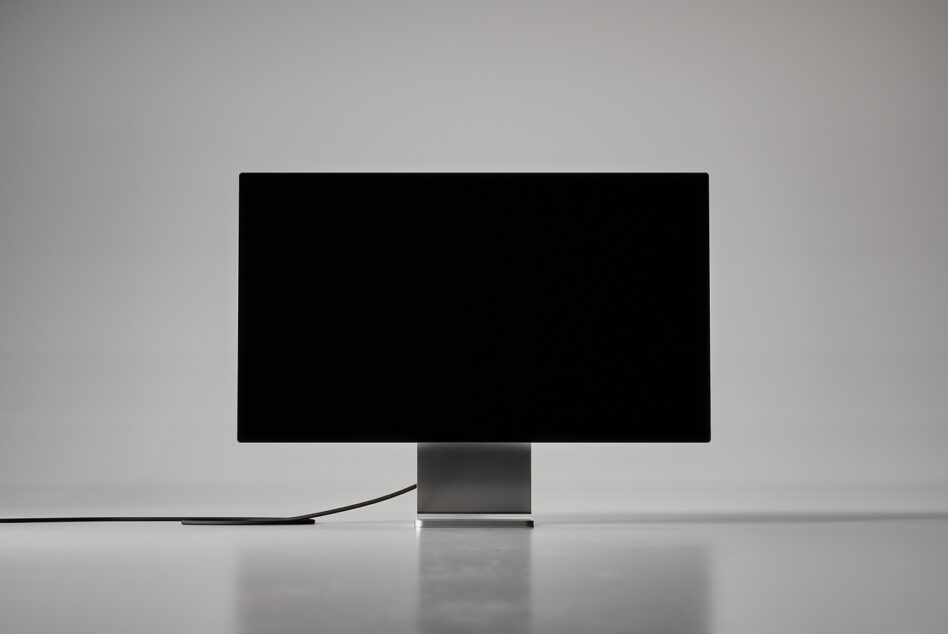 Desktop monitor with black frame on gray pedestal stand, blank screen