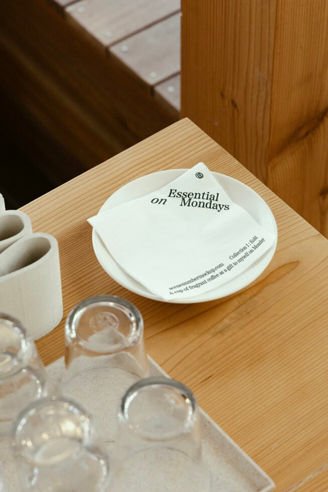 White notecard mockup folded on plate with coffee setting, minimal desk styling