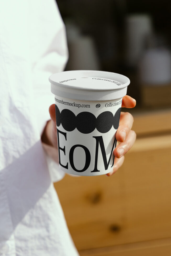 Hand holding customizable yogurt cup mockup with modern typography design ideal for branding projects digital assets graphic design product packaging