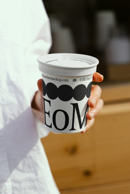 White paper cup mockup being held with blurred background