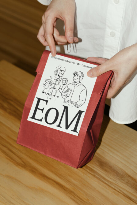 Red paper bag mockup with cartoon design and EoM typography, ideal for branding and packaging projects. Perfect for designers and graphic creators.