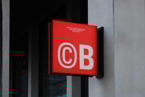 Red outdoor signage mockup on building wall, showcasing bold modern typography. Ideal for designers creating realistic branding and advertising presentations.