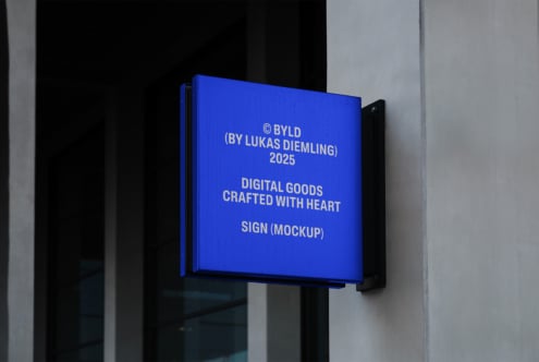 Blue wall-mounted sign mockup with text Digital Goods Crafted With Heart suitable for designers. Modern signage template for branding projects.