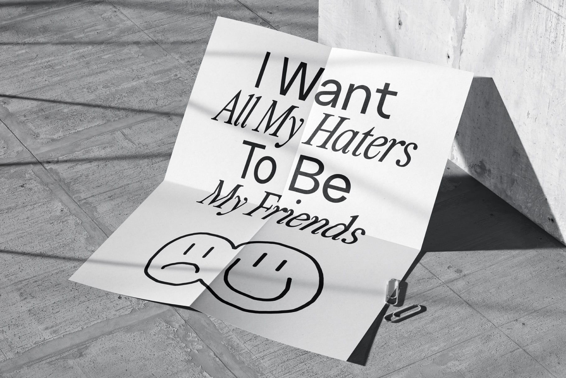 White paper note on concrete with I Want All My Haters To Be My Friends text plus sad faces