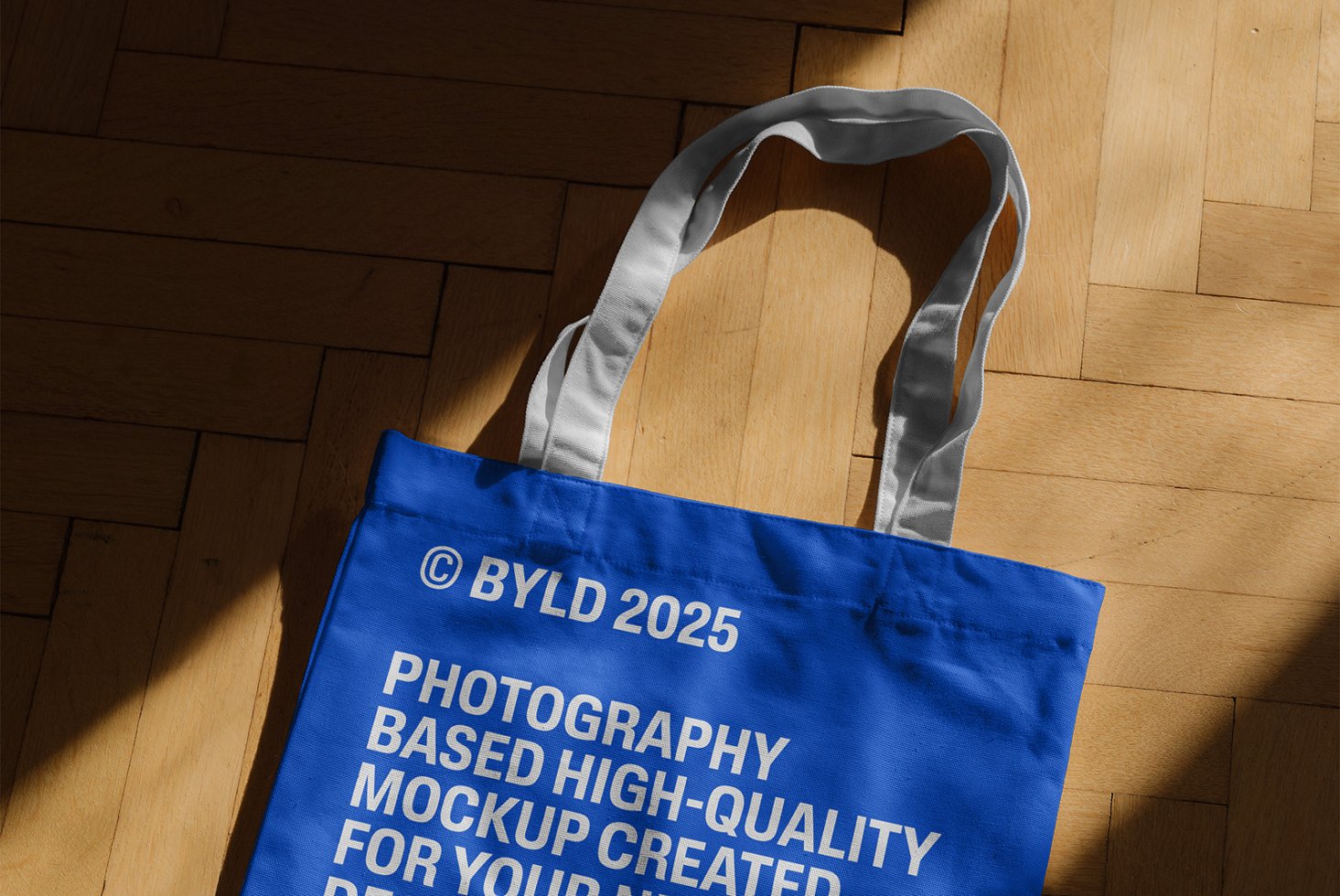 Blue tote bag mockup on wooden floor background sunlight. High-quality design asset for designers. Ideal for creating custom branding templates.